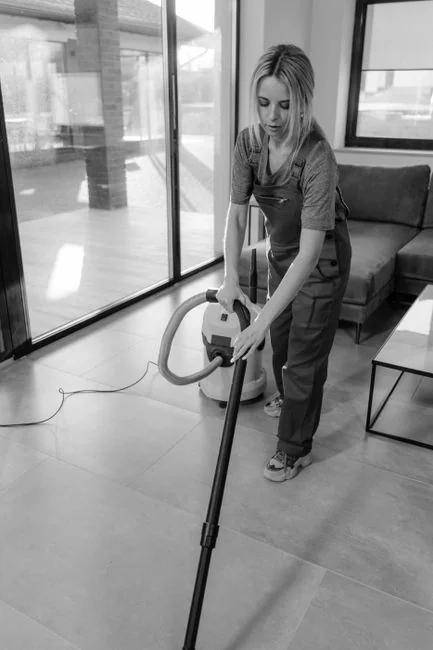Side view of young ethnic male in uniform cleaning floor with mop while working in retro styled restaurant